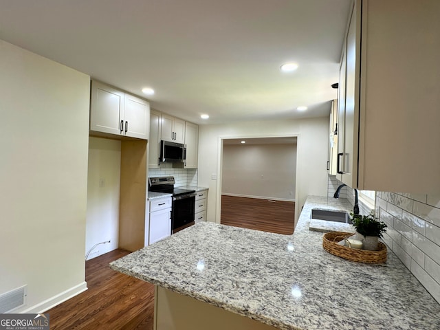 3340 Zingara Rd, Conyers, GA 30012 - kitchen with appliances with stainless steel finishes, a sink, backsplash, light stone counters, and dark wood finished floors