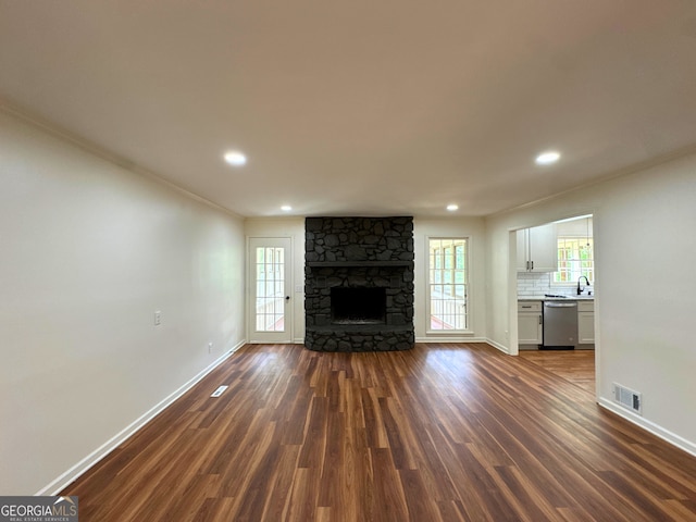 3340 Zingara Rd, Conyers, GA 30012 - unfurnished living room featuring dark wood-style flooring, baseboards, plenty of natural light, recessed lighting, and ornamental molding