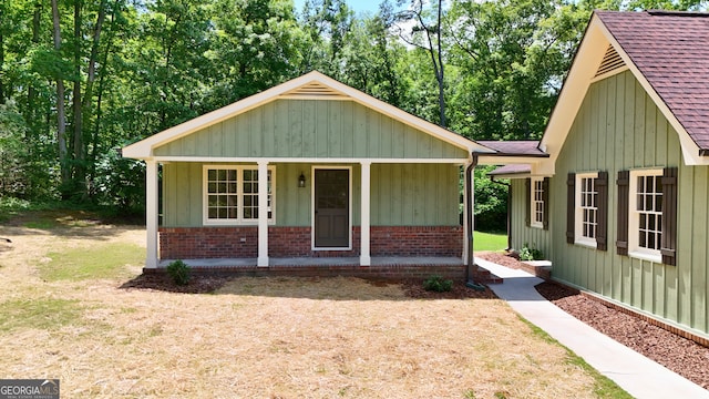 3340 Zingara Rd, Conyers, GA 30012 - view of front facade featuring covered porch, roof with shingles, brick siding, and board and batten siding