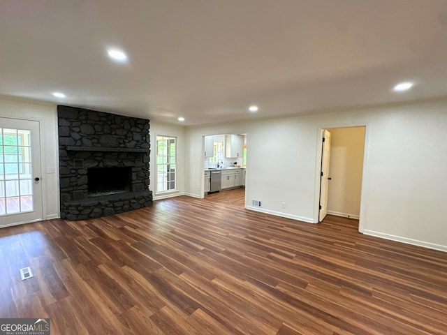 3340 Zingara Rd, Conyers, GA 30012 - unfurnished living room featuring dark wood finished floors, baseboards, recessed lighting, and a stone fireplace