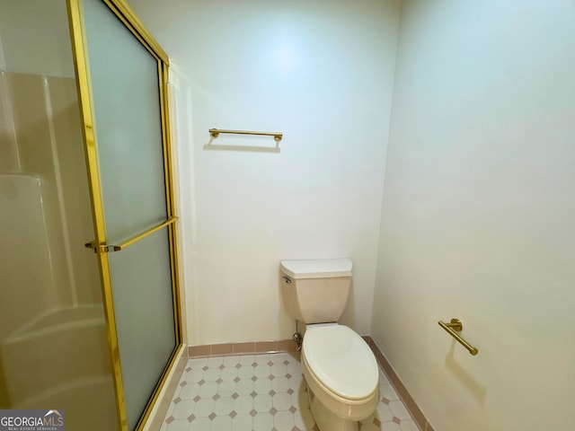 3340 Zingara Rd, Conyers, GA 30012 - bathroom with a shower stall, tile patterned floors, toilet, and baseboards