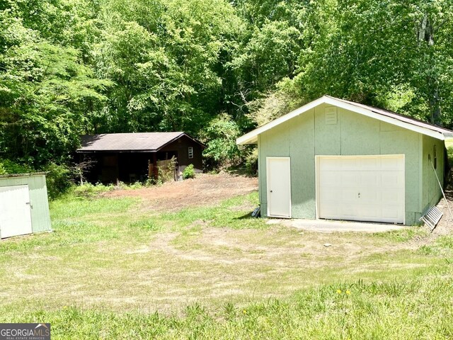 3340 Zingara Rd, Conyers, GA 30012 - view of green lawn with an outdoor structure, a garage, and driveway