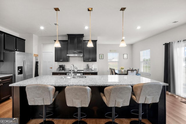 838 Maduro Way, Mcdonough, GA 30253 - kitchen featuring a center island with sink, light wood-style floors, a sink, a kitchen breakfast bar, and recessed lighting
