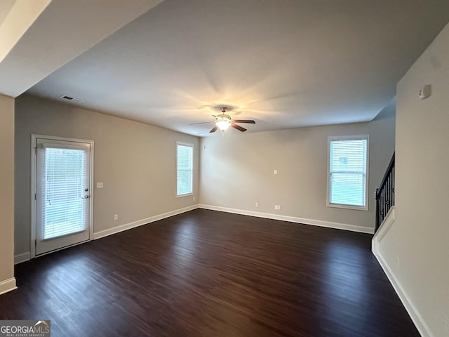 unfurnished living room featuring dark wood finished floors, a ceiling fan, baseboards, and stairway