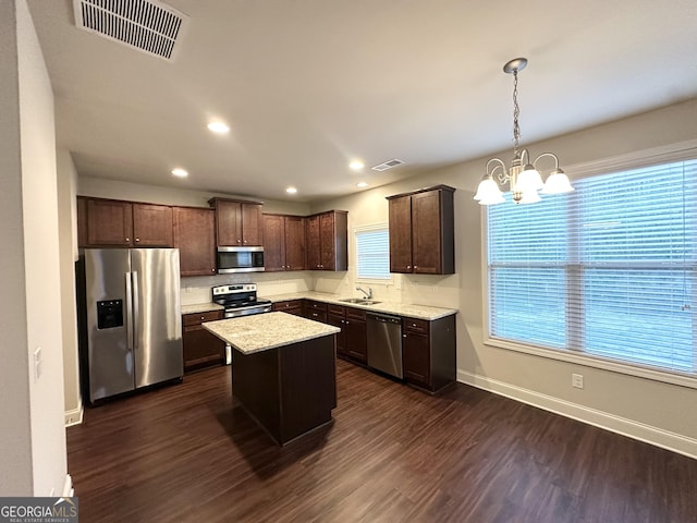 kitchen with appliances with stainless steel finishes, a sink, dark wood-type flooring, dark brown cabinets, and a chandelier
