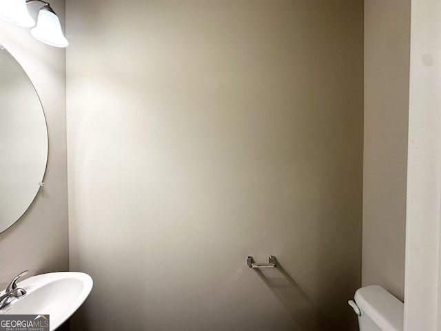 half bath featuring a sink and toilet