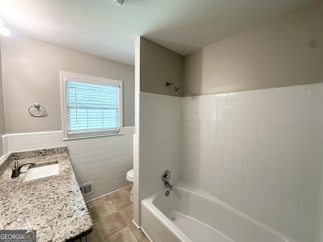4313 Executive Dr, Stone Mountain, GA 30083 - full bathroom featuring tile walls, toilet, shower / bath combination, wainscoting, and vanity
