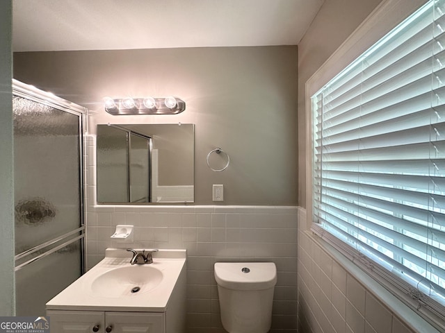 4313 Executive Dr, Stone Mountain, GA 30083 - full bath with a stall shower, vanity, tile walls, toilet, and a wainscoted wall
