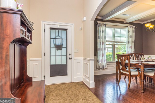 139 Village Park Dr, Newnan, GA 30265 - entryway with crown molding, dark wood-style floors, arched walkways, a chandelier, and a wainscoted wall