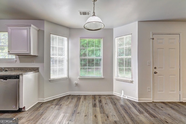 unfurnished dining area with wood finished floors and baseboards