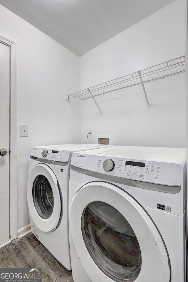 washroom with washer and dryer and wood finished floors