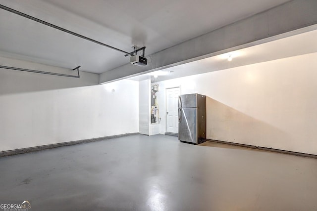 garage featuring freestanding refrigerator and a garage door opener