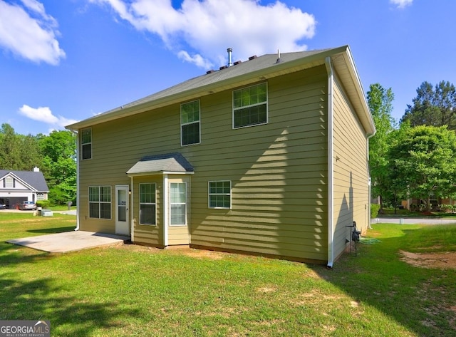 rear view of house featuring a patio area and a lawn