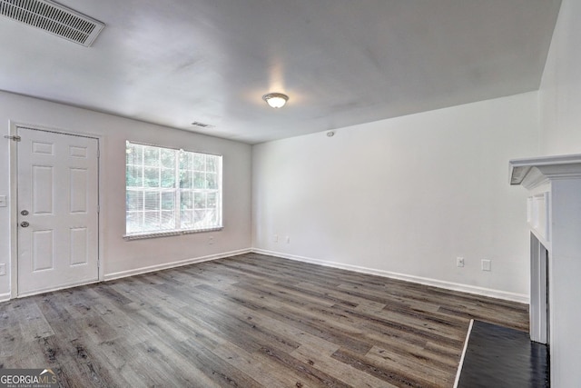 unfurnished living room featuring wood finished floors and baseboards
