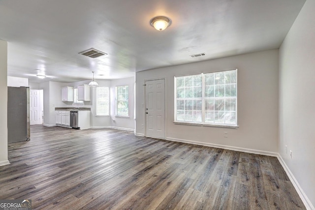 unfurnished living room with baseboards and dark wood-style flooring