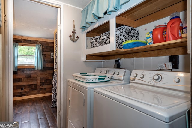 laundry room with wooden walls, separate washer and dryer, and dark wood-style flooring