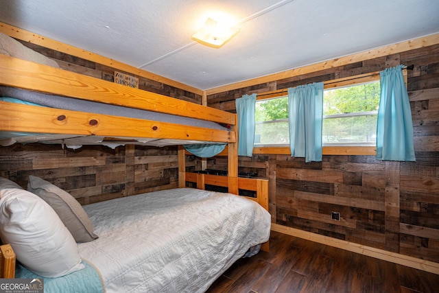 bedroom with wood walls and hardwood / wood-style flooring