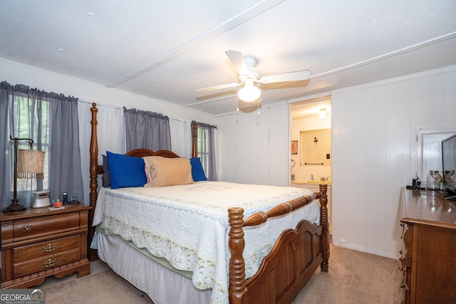 bedroom with light colored carpet, a ceiling fan, and ensuite bath