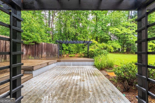 wooden terrace featuring a lawn