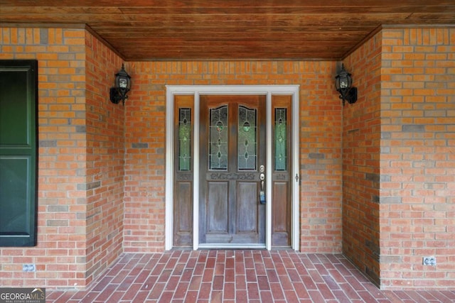 entrance to property with brick siding and covered porch