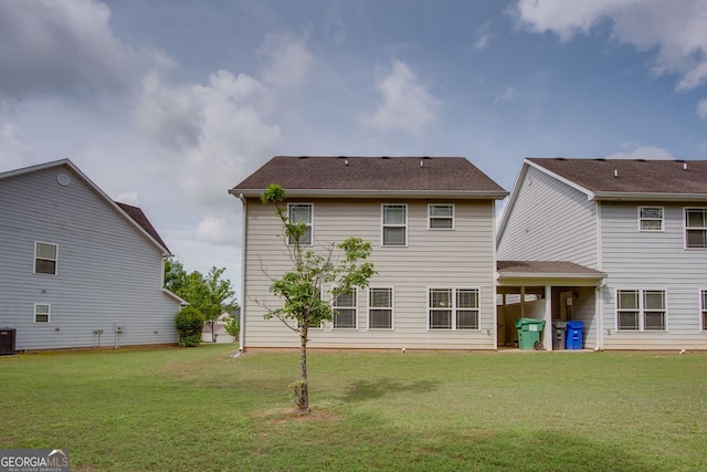back of house with a yard and central AC