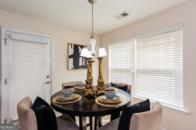 dining area featuring a chandelier and baseboards