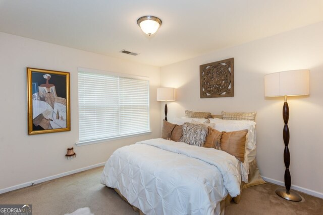 bedroom with light colored carpet and baseboards