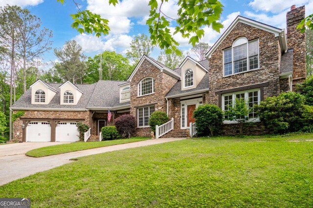 355 Clark Creek Pass, Acworth, GA 30102 - traditional-style house featuring a front lawn, driveway, an attached garage, and a chimney