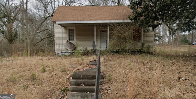 view of front of property with a porch and roof with shingles