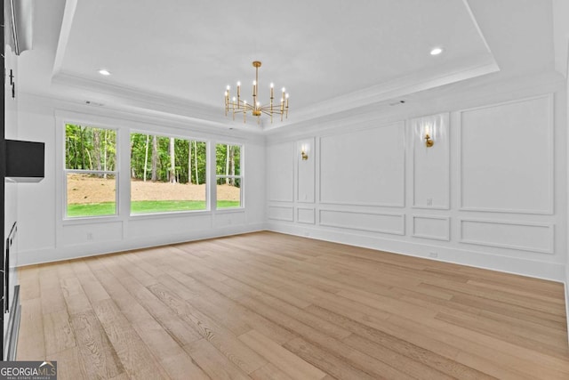 400 Auburn Rd, Auburn, GA 30011 - unfurnished living room with a tray ceiling, a decorative wall, a chandelier, light wood-style flooring, and ornamental molding