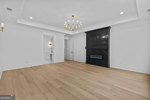 400 Auburn Rd, Auburn, GA 30011 - unfurnished living room with a raised ceiling, light wood-style flooring, a chandelier, ornamental molding, and baseboards