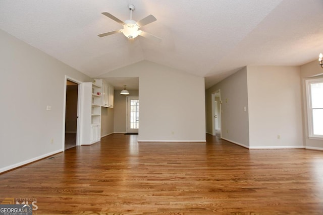 122 Wilson Cir, Carrollton, GA 30117 - unfurnished living room featuring healthy amount of natural light, wood finished floors, ceiling fan, vaulted ceiling, and baseboards