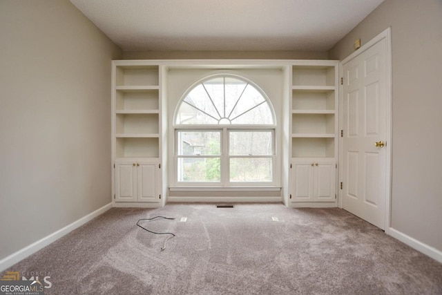 unfurnished living room with carpet flooring and baseboards