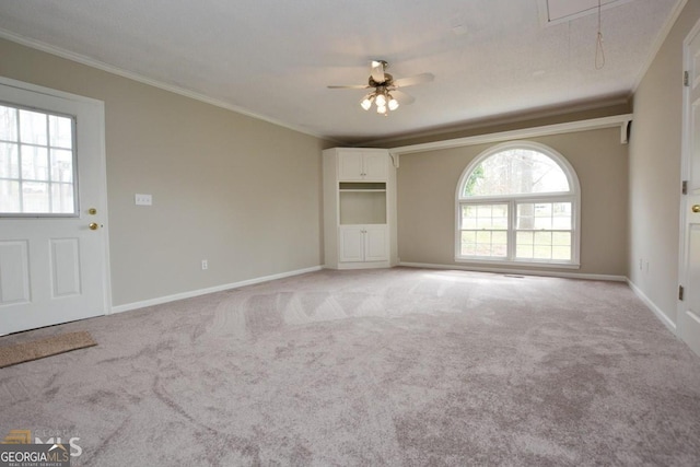 122 Wilson Cir, Carrollton, GA 30117 - unfurnished living room with attic access, crown molding, a ceiling fan, light colored carpet, and baseboards
