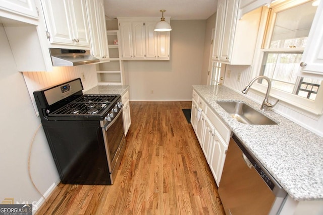 kitchen featuring appliances with stainless steel finishes, under cabinet range hood, a sink, and white cabinetry