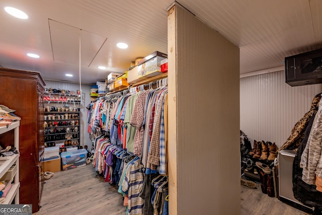 walk in closet featuring attic access and wood finished floors