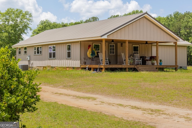 view of front of home with a ceiling fan, driveway, board and batten siding, metal roof, and crawl space