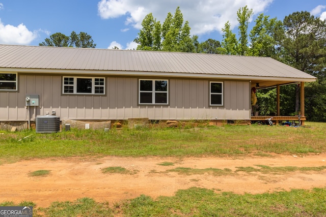 view of side of home featuring cooling unit, metal roof, and board and batten siding