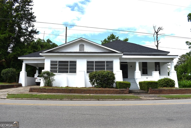 210 E Church St, Sandersville, GA 31082 - view of front of house featuring a porch, driveway, roof with shingles, and an attached carport