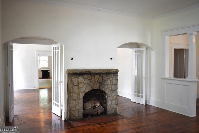 210 E Church St, Sandersville, GA 31082 - unfurnished living room featuring wood finished floors, a stone fireplace, crown molding, arched walkways, and baseboards
