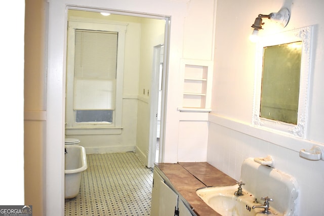 210 E Church St, Sandersville, GA 31082 - bathroom featuring tile patterned floors, vanity, and wainscoting