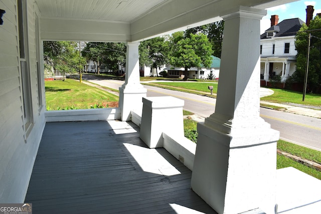 210 E Church St, Sandersville, GA 31082 - wooden terrace with covered porch, a residential view, and a lawn