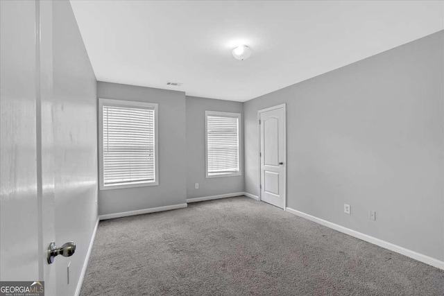 unfurnished room featuring carpet flooring and baseboards