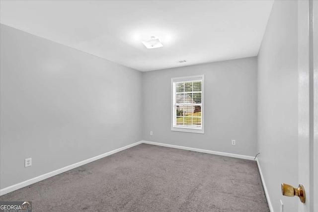 carpeted spare room featuring baseboards
