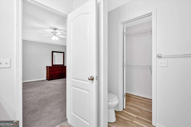 bathroom featuring ceiling fan, toilet, and baseboards