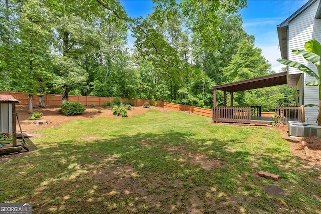 view of yard with central AC unit and a deck