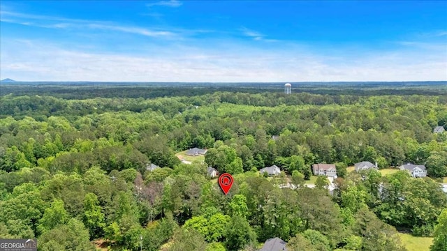 aerial view of property and surrounding area featuring a heavily wooded area