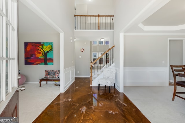 2430 Redbud Meadow Ln, Douglasville, GA 30135 - carpeted entryway featuring a decorative wall, wainscoting, stairway, and a high ceiling