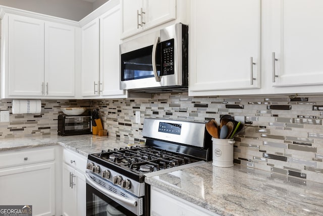 2430 Redbud Meadow Ln, Douglasville, GA 30135 - kitchen with appliances with stainless steel finishes, white cabinets, decorative backsplash, and light stone countertops