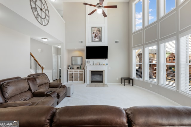 2430 Redbud Meadow Ln, Douglasville, GA 30135 - living area with a high ceiling, a ceiling fan, carpet, a fireplace with flush hearth, and healthy amount of natural light
